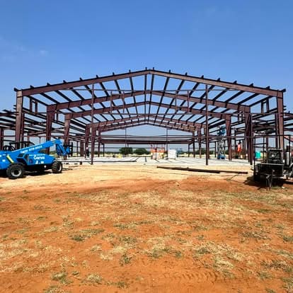 Red iron purlin frame going up on a Natalia metal building project